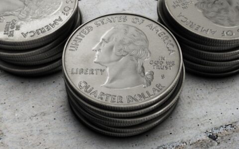 Detailed image of stacked silver US quarter coins showing engraved design.