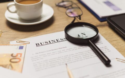A business workspace setup featuring documents, coffee, and financial elements.