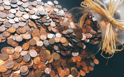 Spilled jar of pennies creating a pattern of coins representing savings and finance.